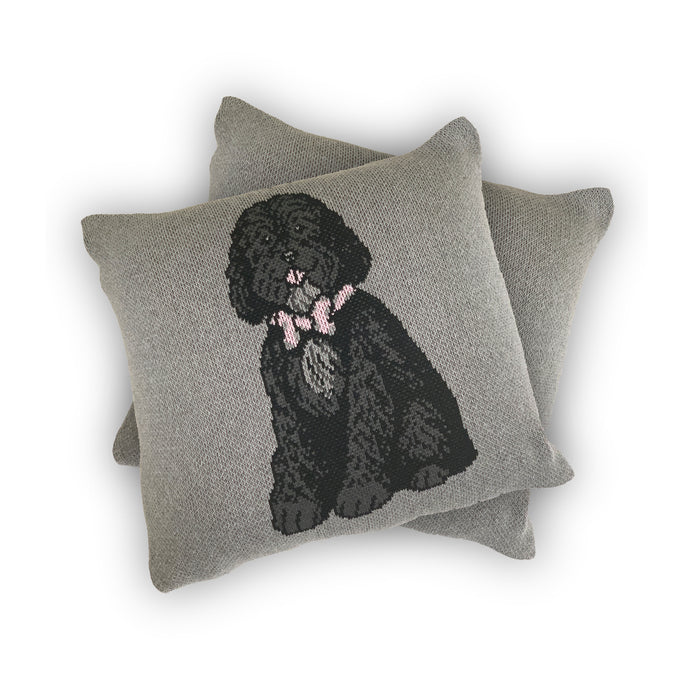 Grey knitted pillow with a dog in a bow tie